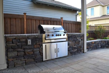 Outdoor Kitchen with Stone Countertops, SS Doors, Stone Siding